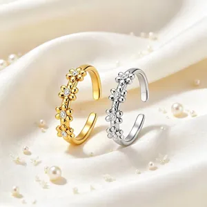 Makro-Detail von goldenen und silbernen Gänseblümchen-Ringen mit Kristallbesatz