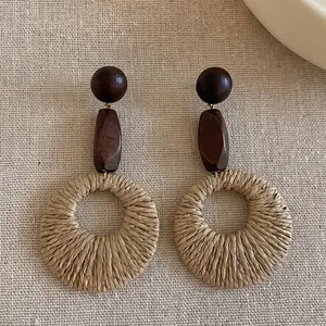 Detailed close-up showing texture of vintage geometric wood and woven raffia hoop earrings
