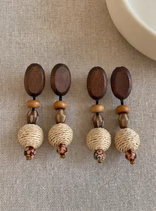 Detailed view of handmade wooden and woven straw drop earrings with vintage beads
