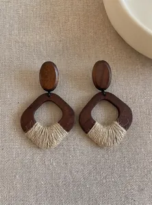 Detailed close-up of vintage wooden geometric earrings with woven hemp rope wrapping