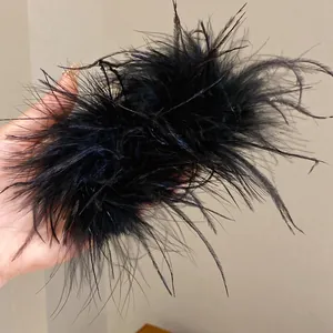 Détail des boucles d'oreilles en plumes noires avec tiges en argent pour femme.