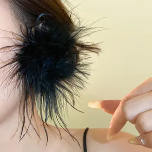 Gros plan détaillé d'une boucle d'oreille fleur en plumes noires portée par un mannequin
