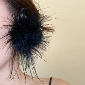 Gros plan sur d'élégantes boucles d'oreilles fleurs en plumes noires sur un mannequin