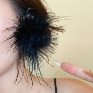 Vue macro d'une grande boucle d'oreille en plumes noires montrant la texture douce