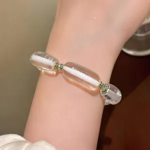 Elegante pulsera de resina transparente con núcleo blanco y espaciadores de strass verde