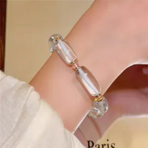Primer plano de una elegante pulsera coreana de resina con detalles dorados en la muñeca