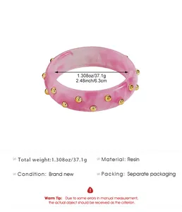 Macro detail of pink resin bangle featuring gold stud accents and size measurements