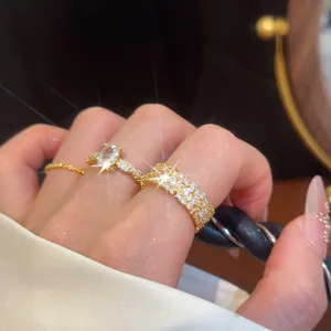 Nahaufnahme eleganter Goldringe mit ovalen Zirkoniasteinen und glänzenden Pavé-Fassungen.