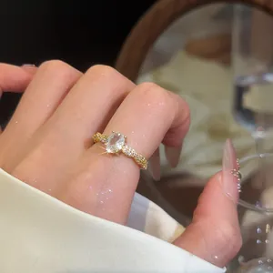Nahaufnahme eines eleganten, vergoldeten, ovalen Zirkonia-Rings an einem gepflegten Finger