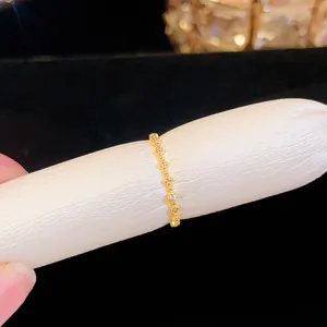 Makroaufnahme eines zierlichen Goldrings mit schimmerndem Zirkonia auf weißem Fingerhalter