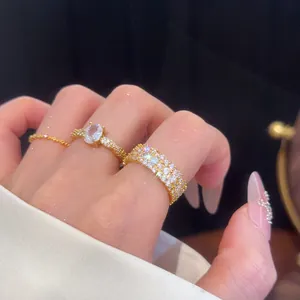Nahaufnahme eines funkelnden ovalen Zirkonia-Rings und eines Pavé-Bandes am Finger