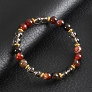 Vue détaillée d'un bracelet en perles d'agate marron sur une surface en cuir noir