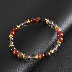 Détail macro d'un bracelet en perles d'agate brune et quartz fumé sur fond en cuir noir