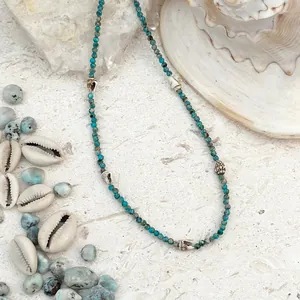 Primo piano dettagliato di una collana stile spiaggia con perline blu e conchiglie naturali