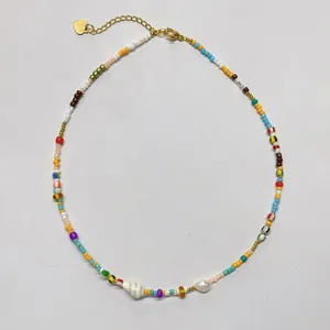 Dettaglio ravvicinato di una vivace collana di perline colorate con conchiglia e perla