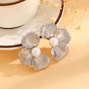 Detailed close-up of elegant silver-tone flower stud earrings with a central pearl