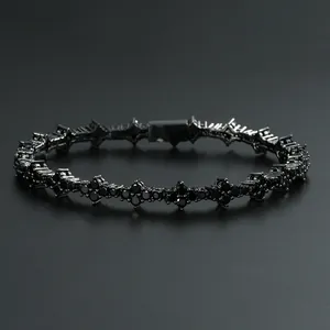 Gros plan macro d'un bracelet tennis fleur en métal noir avec pierres de zircon