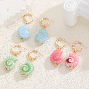 Vue détaillée des boucles d'oreilles coquillage style océan en bleu, vert et rose.