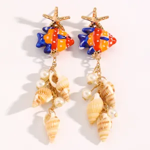 Vue détaillée de boucles d'oreilles marines avec étoile de mer, poissons et perles