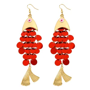 Vue détaillée de boucles d'oreilles poisson avec paillettes rouges et nageoires dorées