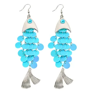 Gros plan détaillé de boucles d'oreilles pendantes en forme de poisson à paillettes.