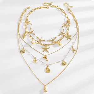 Detail of Bohemian gold layered necklace with starfish, conch and shell charms