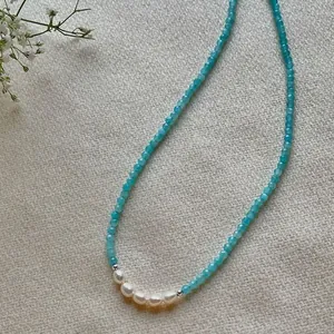 Detailed macro view of a blue natural stone beaded choker necklace with white pearls