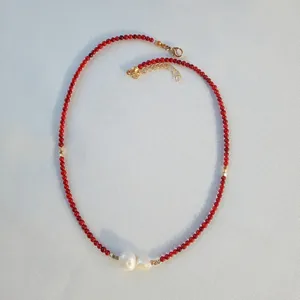 Detail view of handmade red natural stone necklace with two freshwater pearls