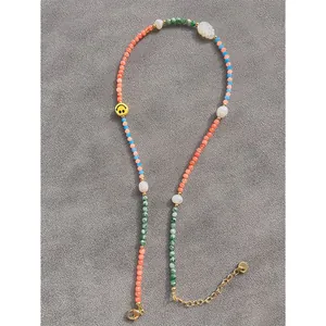 Macro detail of handmade colorful natural stone necklace with freshwater pearls and smiley bead