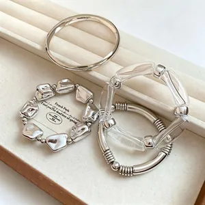 Close-up of vintage silver beaded bracelets and resin bangles set on a jewelry tray