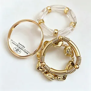 Close-up detail of a 3-piece set featuring gold-tone and clear resin beaded bracelets