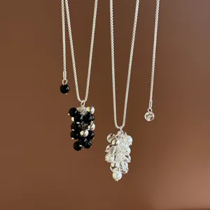 Detailed view showing two minimalist silver cluster bead necklaces in black and clear styles
