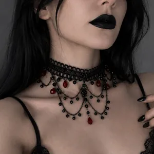 Detailed macro shot of vintage black lace gothic choker with red crystal beaded tassels.