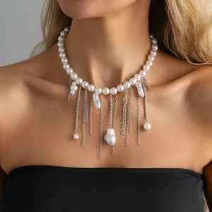 Detail einer eleganten Perlenhalskette mit silbernen Quasten und Barockperlen am Model