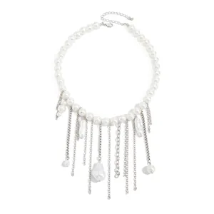 Detailansicht einer weißen Perlenkette mit eleganten silbernen Quasten und Fransen.