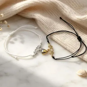 Close-up of magnetic heart and ECG couple bracelets on a soft knit background.