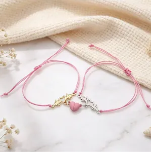 Detailed view of pink woven bracelets with magnetic heart and ECG charm