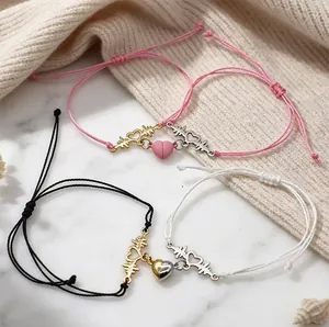 Close-up showing the magnetic heart clasp on heartbeat EKG braided cord couple bracelets set