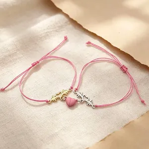 Pink magnetic ECG heartbeat couple bracelets on soft textured linen background