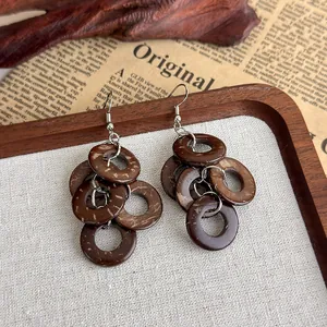 Detailansicht von vintage braunen Holzohrringen mit mehreren Ringen auf rustikalem Grund.