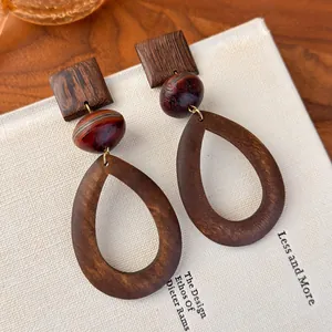 Detailed macro shot of vintage wooden teardrop earrings with a natural brown grain finish
