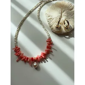 Dettaglio della collana con corallo rosa irregolare e perle d'acqua dolce barocche
