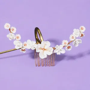 Elegant bridal hair comb featuring white flowers and gold wiring on a lavender background