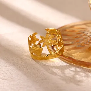 Primo piano dettagliato di un anello dorato a tema oceanico con conchiglie e palme