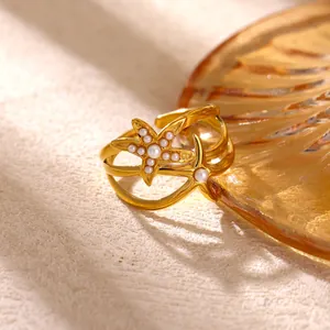 Dettaglio macro di un anello a stella marina dorata con perle bianche eleganti