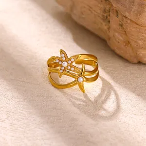 Dettaglio di un anello a forma di stella marina dorata con perle bianche eleganti