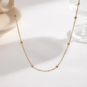 Close-up of a minimalist gold-plated satellite chain necklace with small beads