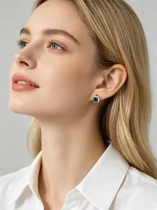 Elegant model wearing square emerald green zircon stud earrings with silver halo detail