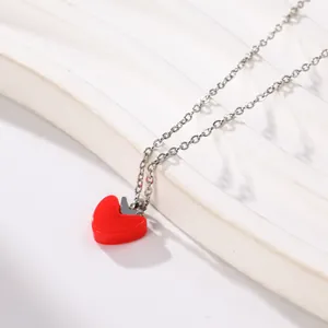 Detailed macro view of a red drip oil heart pendant on a silver titanium steel chain