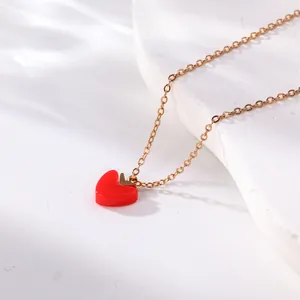 Close-up detail of a red heart pendant on a delicate gold titanium steel necklace